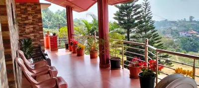 a balcony with chairs and potted plants on it at Holidayincoorg Royal Mansion in Madikeri