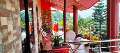 a balcony with a table and chairs and a window at Holidayincoorg Royal Mansion in Madikeri