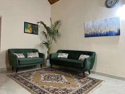 two green chairs and a couch in a living room at Rustic Village Farmhouse in Bengaluru