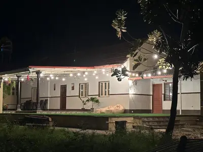a house with lights on it at night at Rustic Village Farmhouse in Bengaluru