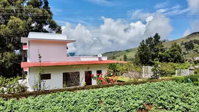 a house in the middle of a field of crops at Mountain Mansion Kodai in Kodaikānāl