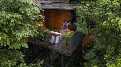 an overhead view of a house with a woman standing on a balcony at Crystal Kuruva Nature Resort & Spa in Wayanad