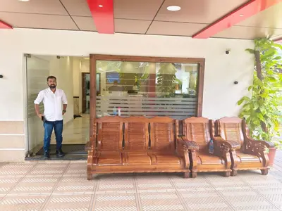 a man standing next to a group of chairs at MARINA SUITES AIRPORT HOTEL in Cochin