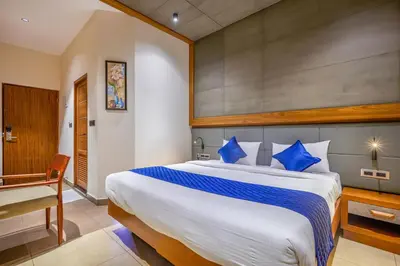 a bedroom with a large bed with blue pillows at HOTEL CASON INTERNATIONAL in Kondotti