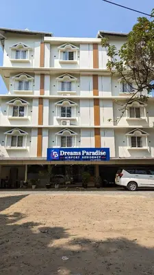 a building with a car parked in front of it at Dreams Paradise Airport Residency in Nedumbassery
