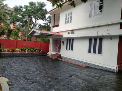 a white house with a red fence at Navarang Villa in Kalpetta