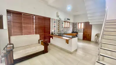 a living room with a chair and a counter at Mountain Abode in Kodaikānāl