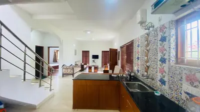 a kitchen with a sink and a staircase at Mountain Abode in Kodaikānāl