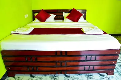 a bed in a green room with red pillows at Paradise Harmony Beach Resort in Singānallūr