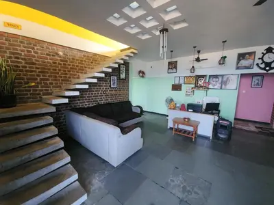 a living room with a couch and a brick wall at Paradise Harmony Beach Resort in Singānallūr