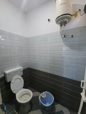 a bathroom with a toilet and a trash can at Paradise Harmony Beach Resort in Singānallūr