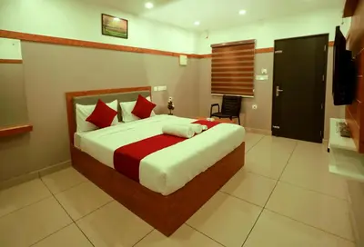 a bedroom with a large bed with red and white pillows at The Rosetta Castle in Kalpetta