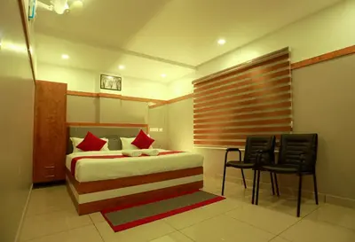 a bedroom with a bed and a table and chairs at The Rosetta Castle in Kalpetta