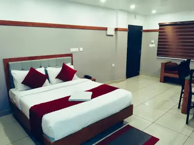 a bedroom with a large bed with red pillows at The Rosetta Castle in Kalpetta