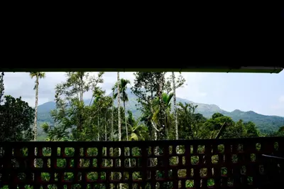 a computer keyboard with a view of trees and mountains at Mayflower Holiday Villa in Meppādi