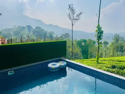 a swimming pool with two inflatable boats in the water at Mayflower Holiday Villa in Meppādi