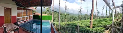 a house with a balcony with a view of a mountain at Mayflower Holiday Villa in Meppādi