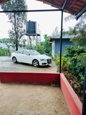 a white car parked in front of a house at Mayflower Holiday Villa in Meppādi
