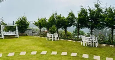 a lawn with white tables and a soccer goal at Orchard Valley View in Ooty