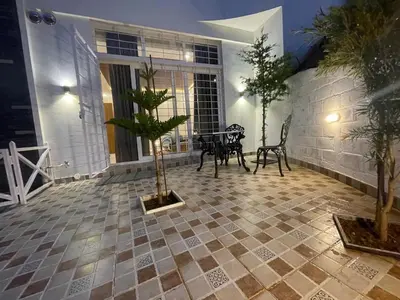 a patio with a table and chairs in a house at Orchard Valley View in Ooty