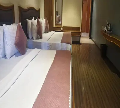 two beds in a hotel room with two at Hotel Glanton Manor in Ooty