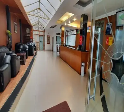 a lobby of a hospital with couches and chairs at Hotel Glanton Manor in Ooty