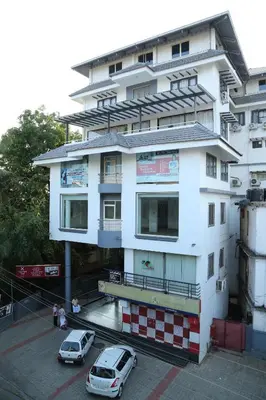 two cars parked in front of a white building at hazmi inn in Perintalmanna
