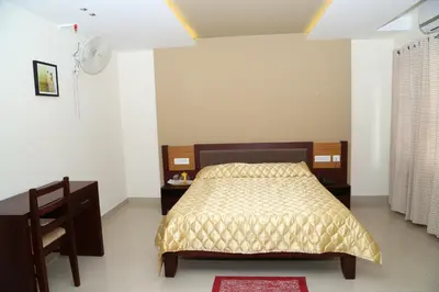 a bedroom with a bed and a desk and a fan at hazmi inn in Perintalmanna