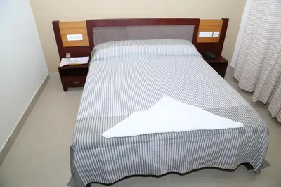 a bed with a white shirt on top of it at hazmi inn in Perintalmanna
