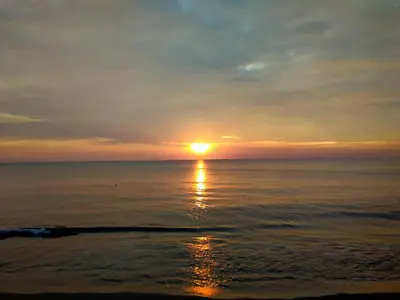 a sunset over the ocean with the sun in the sky at ENOCEAN HOMESTAY in Cherai Beach