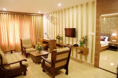 a hotel room with a bedroom and a living room at VKJ INTERNATIONAL in Perumbavoor