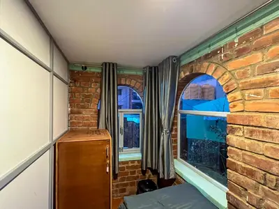 a room with a brick wall and a window at Rahees Bi Roambay - Backpacker Hostel in Mysore