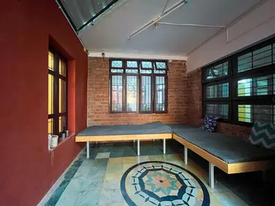 a room with two beds and a brick wall at Rahees Bi Roambay - Backpacker Hostel in Mysore