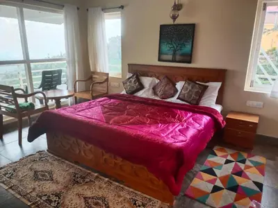 a bedroom with a large bed with a red blanket at MOUNTAIN OF MAGICS in Ooty