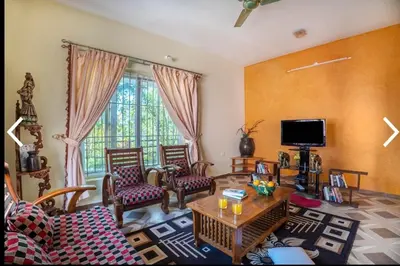 a living room with a couch and a table at MOUNTAIN OF MAGICS in Ooty