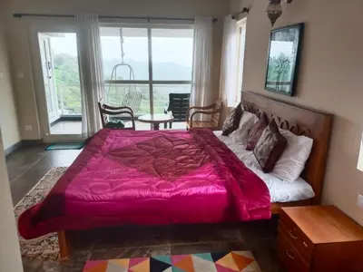 a bedroom with a large bed and a balcony at MOUNTAIN OF MAGICS in Ooty