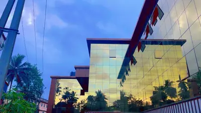a reflection of a building with palm trees on it at MARZA INN in Kalpetta