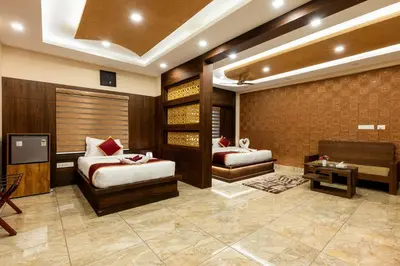 a room with two beds and a tv in it at MARZA INN in Kalpetta