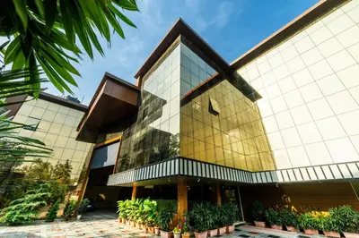 a building with a glass facade with potted plants at MARZA INN in Kalpetta