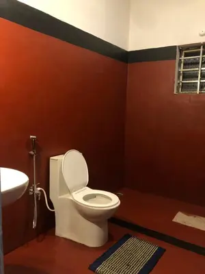 a bathroom with a toilet and a sink at Amberleaf Estate 4BHK Homestay Coorg by Homeyhuts in Virajpet