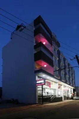 a building with pink lights on the side of it at moriz inz in Mysore