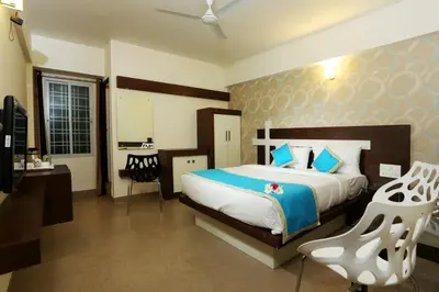a bedroom with a bed and a chair in it at moriz inz in Mysore