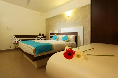 a bedroom with a bed and a flower on a table at moriz inz in Mysore