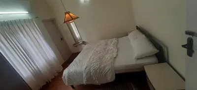 a small bedroom with a bed and a lamp at Dew Drops Cottage Coonoor By Lexstays in Coonoor