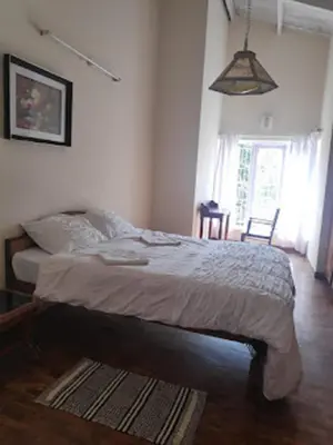 a bedroom with a bed in a room with a window at Dew Drops Cottage Coonoor By Lexstays in Coonoor