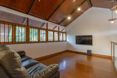 a living room with a couch and a flat screen tv at StayVista at Mountain Rain - Breakfast Included in Wayanad