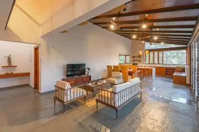 a large living room with couches and a dining room at StayVista at Mountain Rain - Breakfast Included in Wayanad