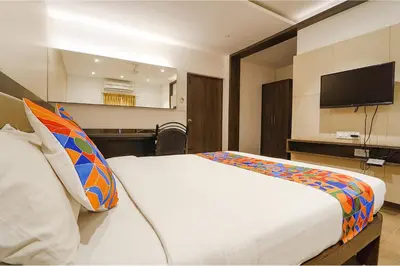 a bedroom with a bed with a tv on the wall at FabHotel Karpagam - 900m from Nehru Stadium in Coimbatore