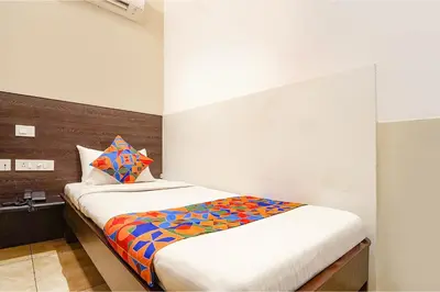 a bedroom with a bed with a colorful blanket on it at FabHotel Karpagam - 900m from Nehru Stadium in Coimbatore