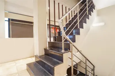 a staircase in a house with a metal railing at FabHotel Karpagam - 900m from Nehru Stadium in Coimbatore